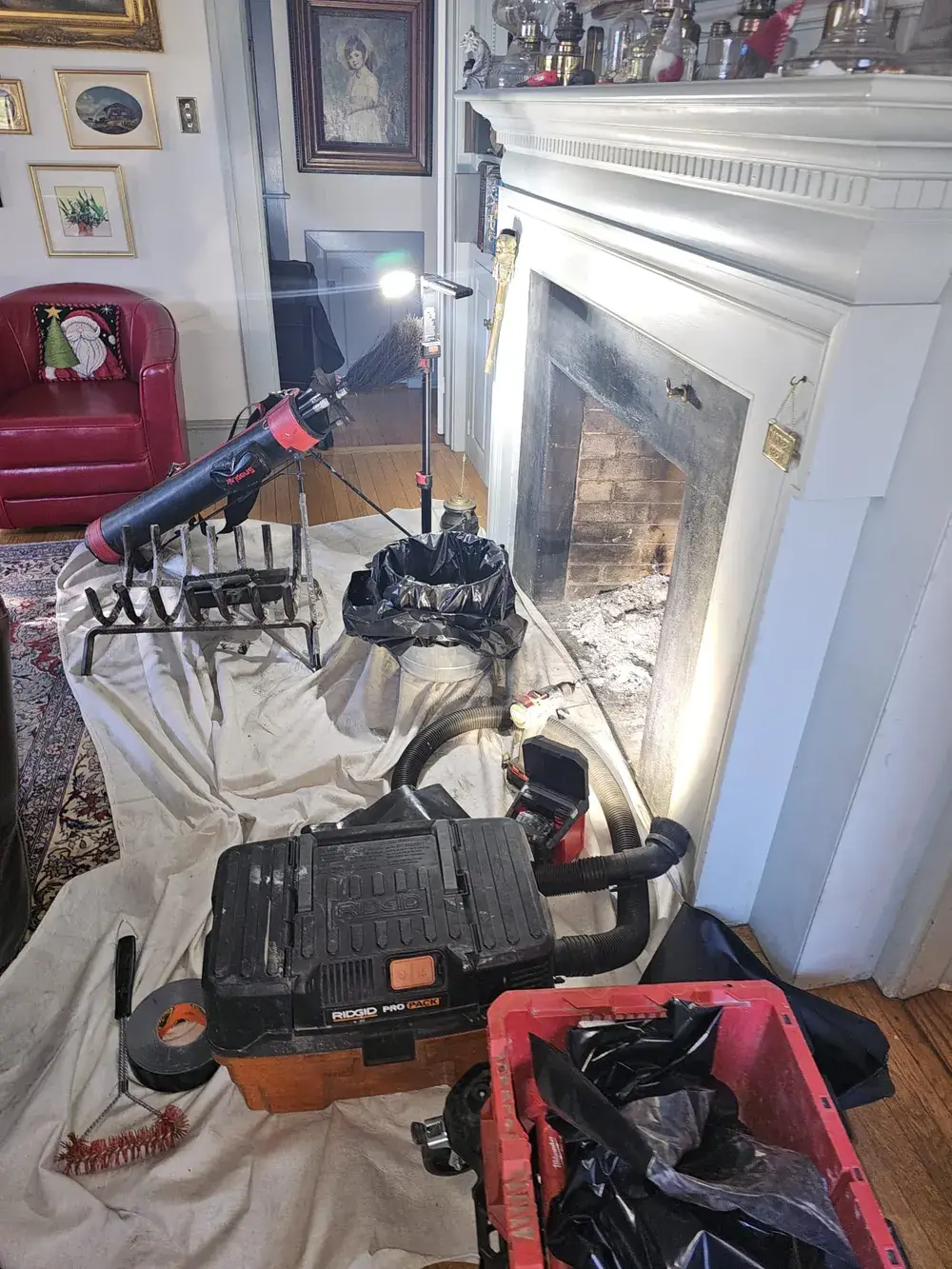 Chimney cleaning equipment staged at a fireplace with dust protection